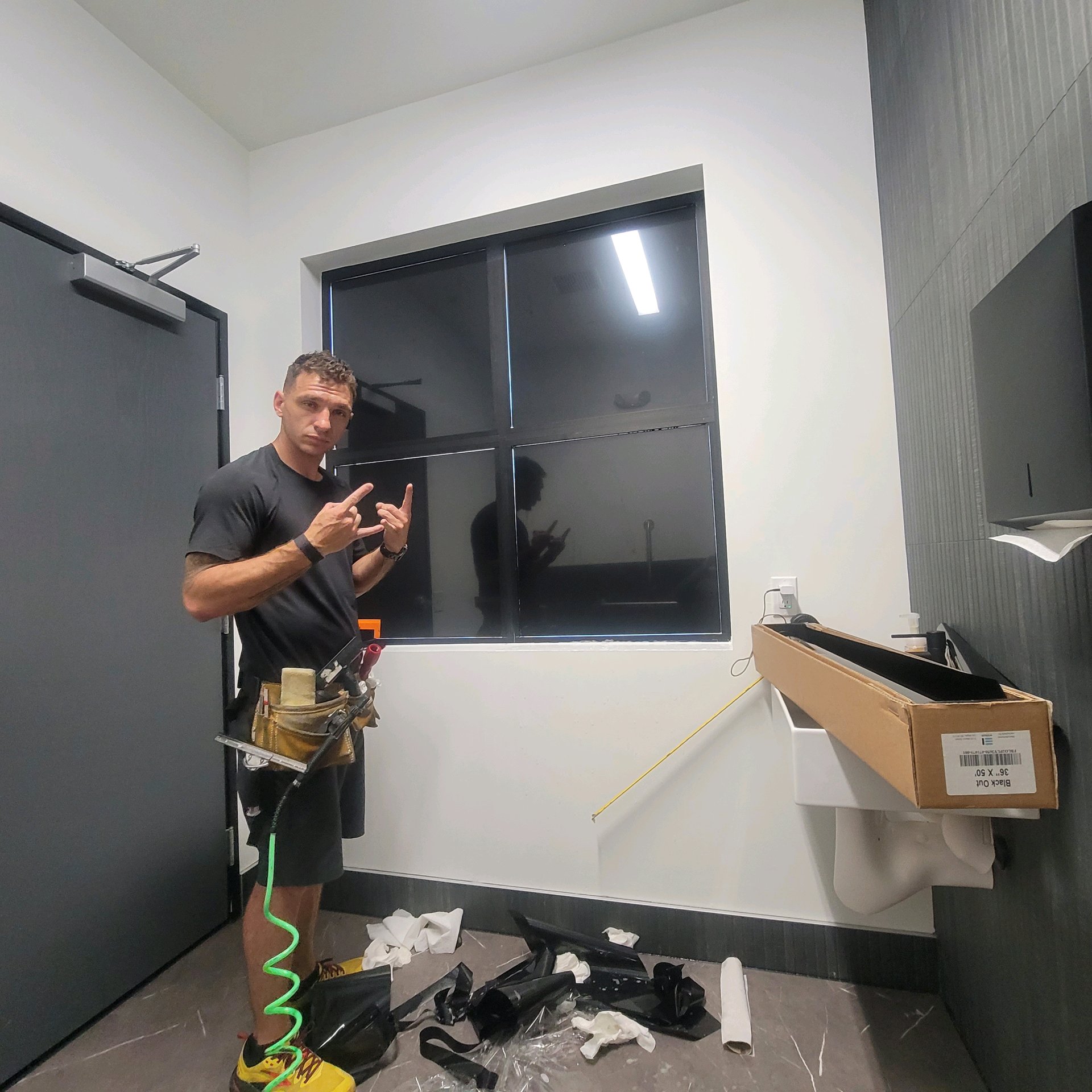 Technician posing in front of completed tinted commercial window