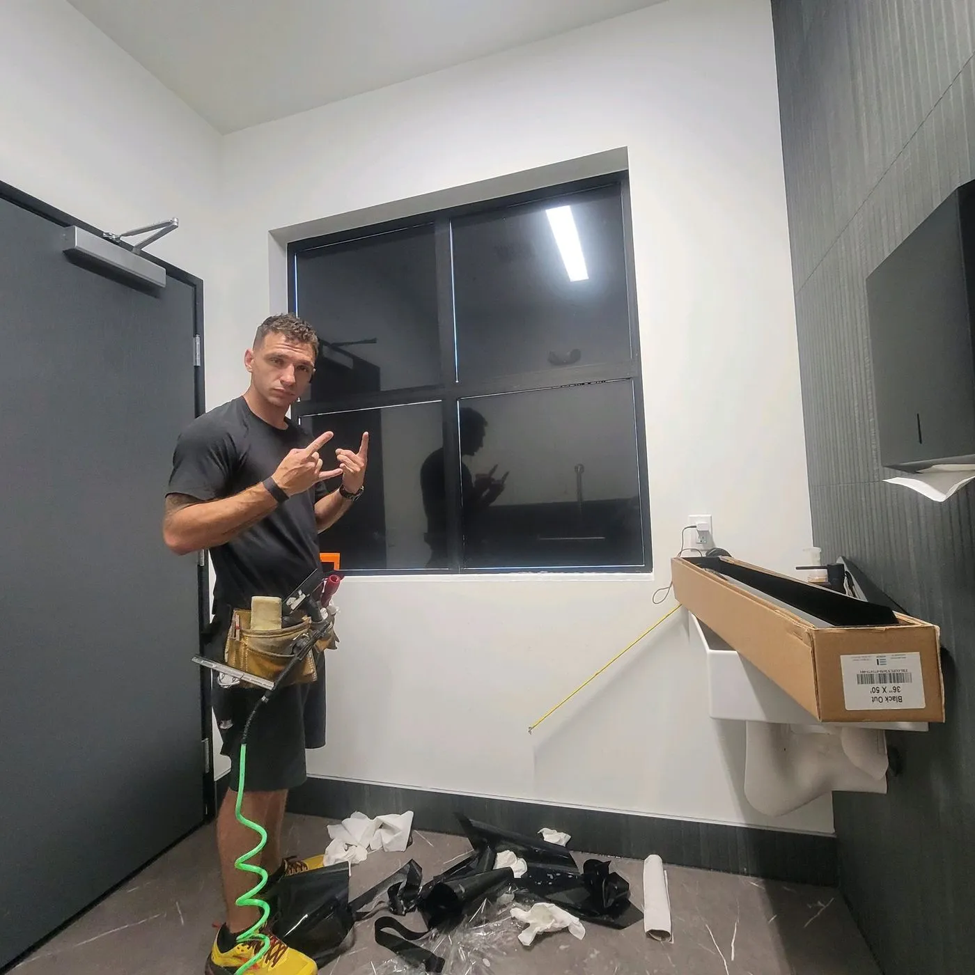 Technician posing in front of completed tinted commercial window