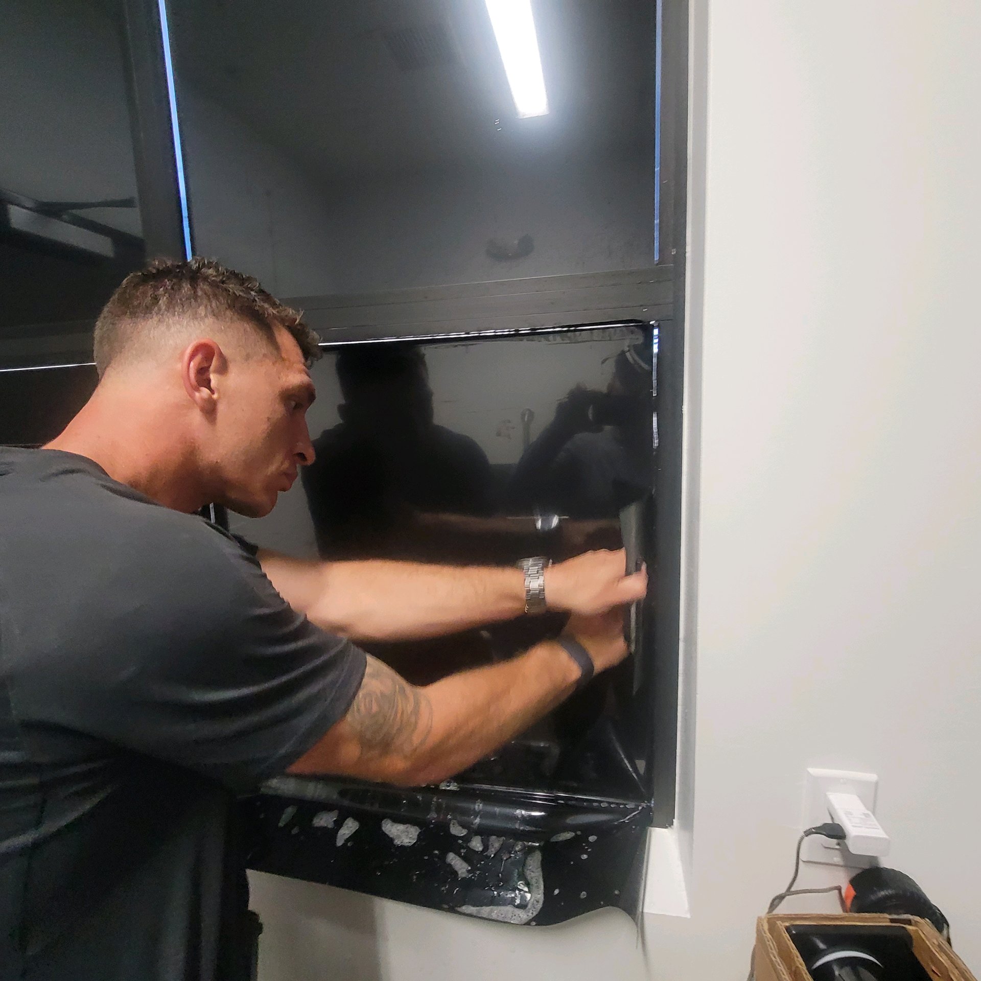 Technician squeegeeing corner of large tinted panel