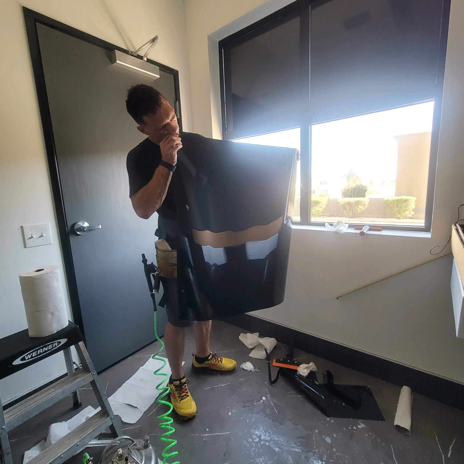 Technician checking cut film panel before application