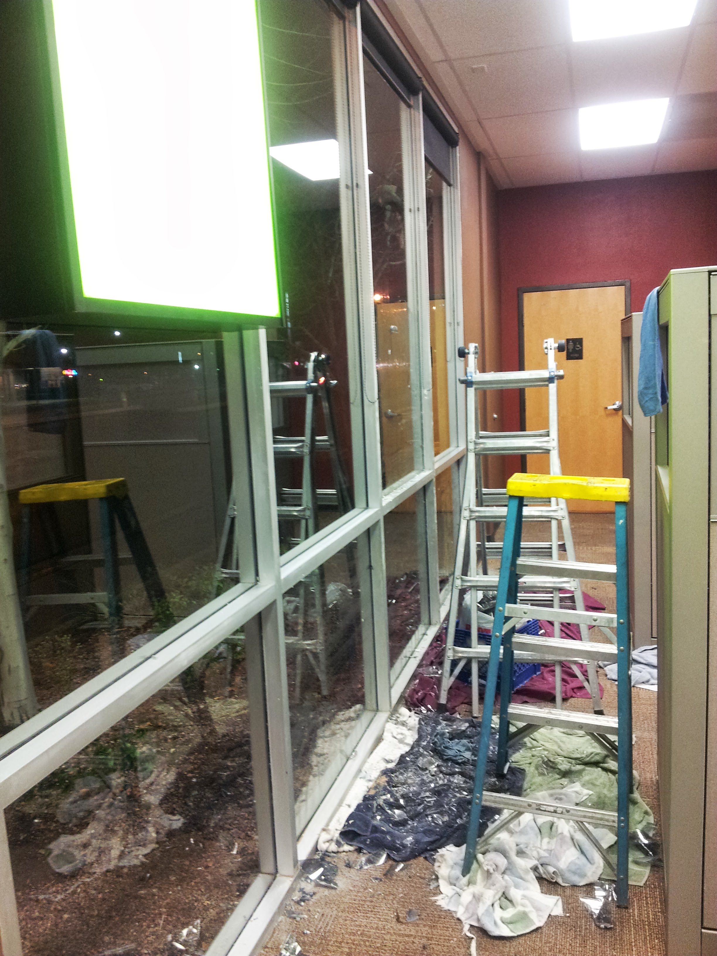 Commercial window film installation night shot multiple ladders curtain wall