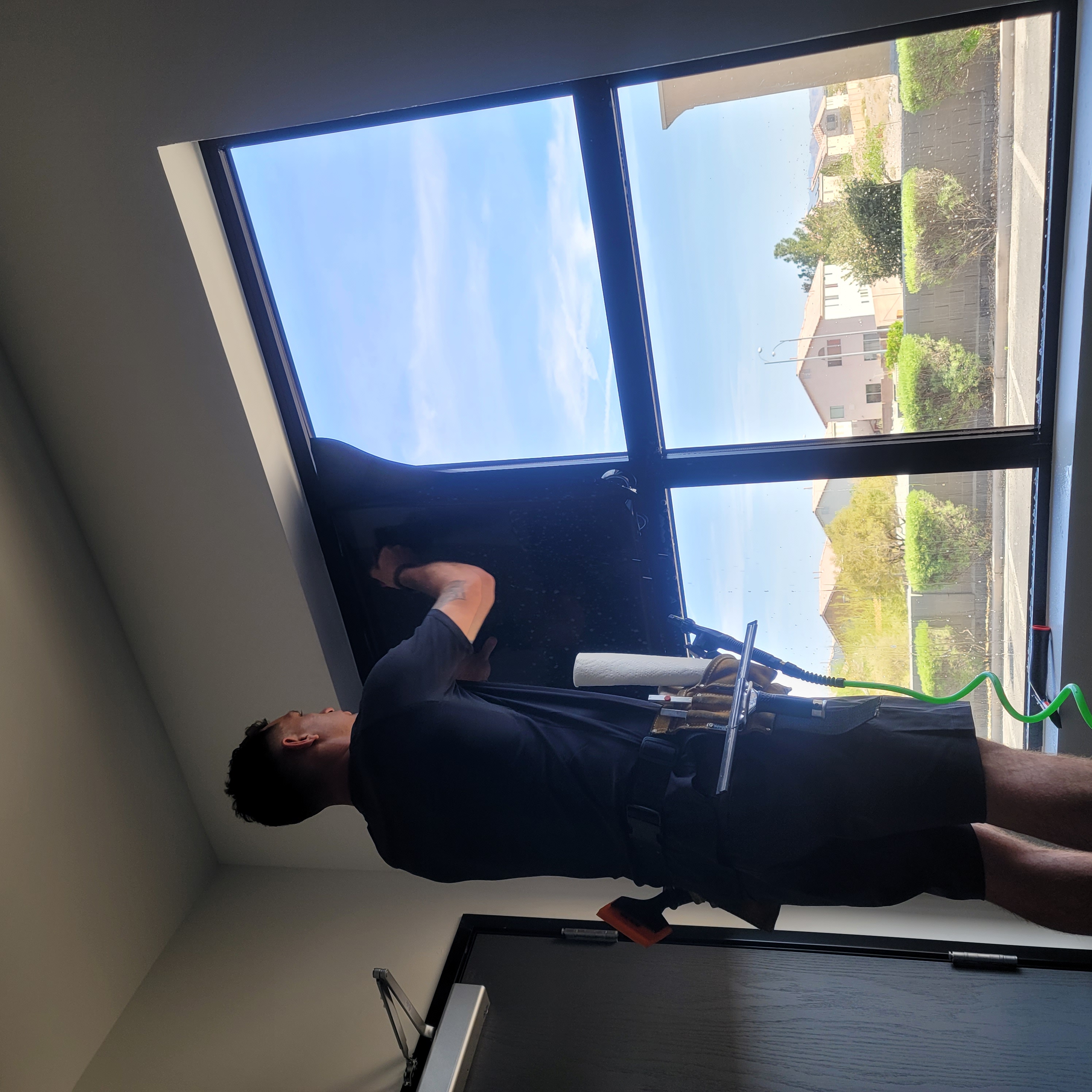 Window film being pressed onto commercial black-frame window