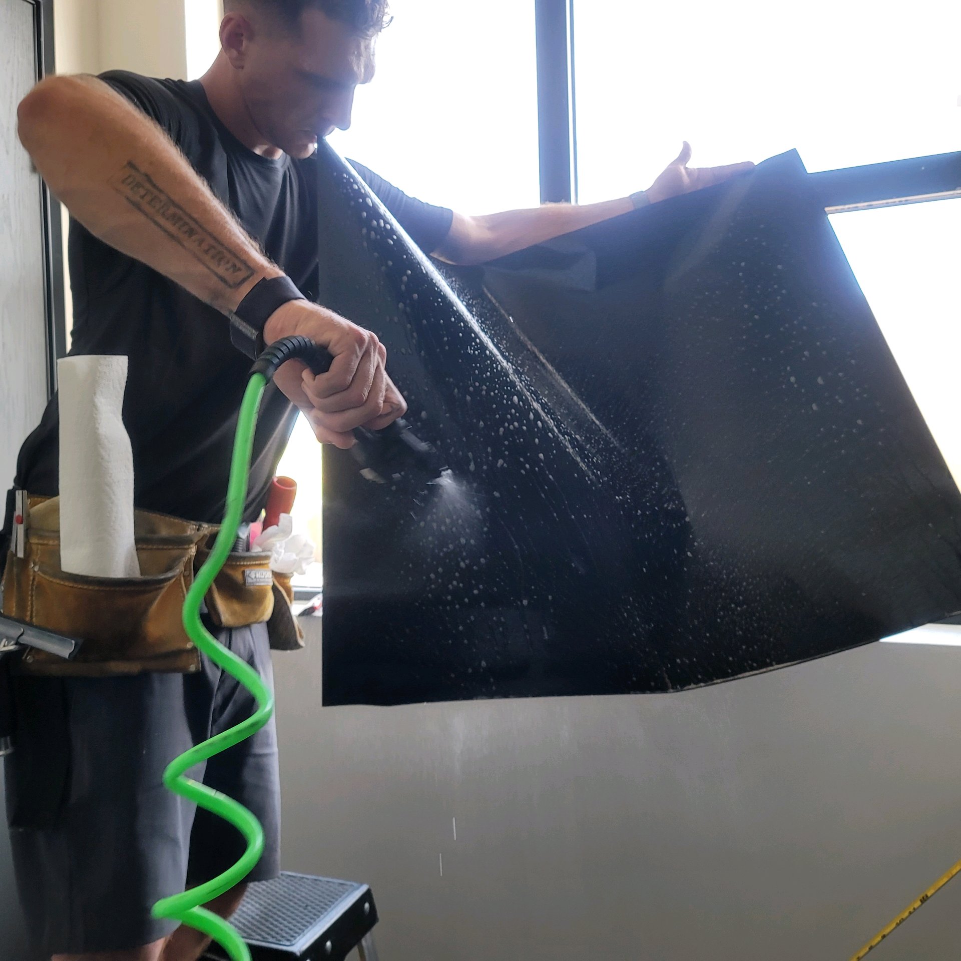 Spraying water on solar film before application