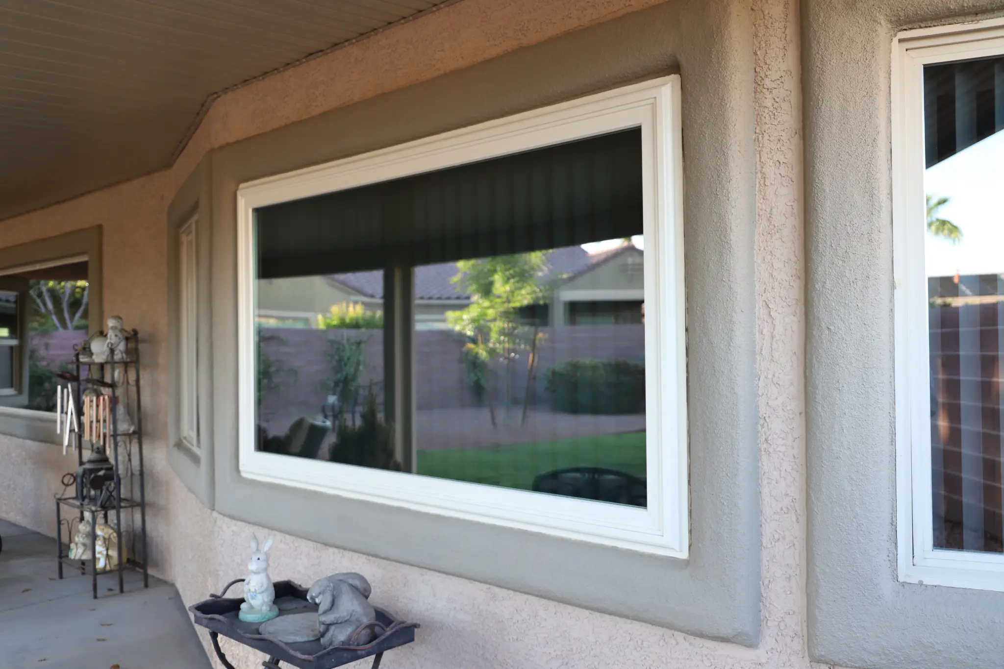 Patio window after solar tinting with outdoor decor