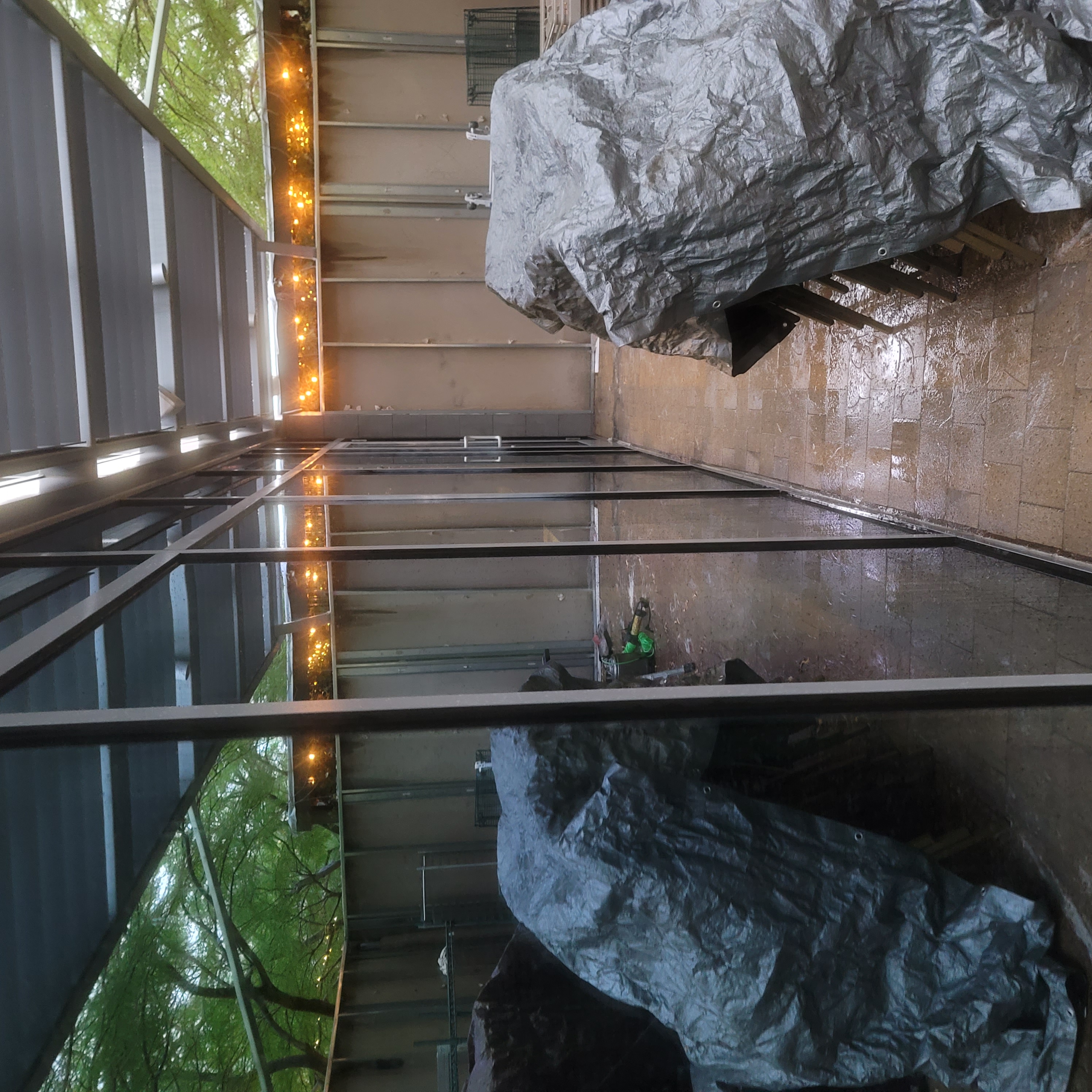 Glass patio enclosure before window tinting clear panels rainy evening