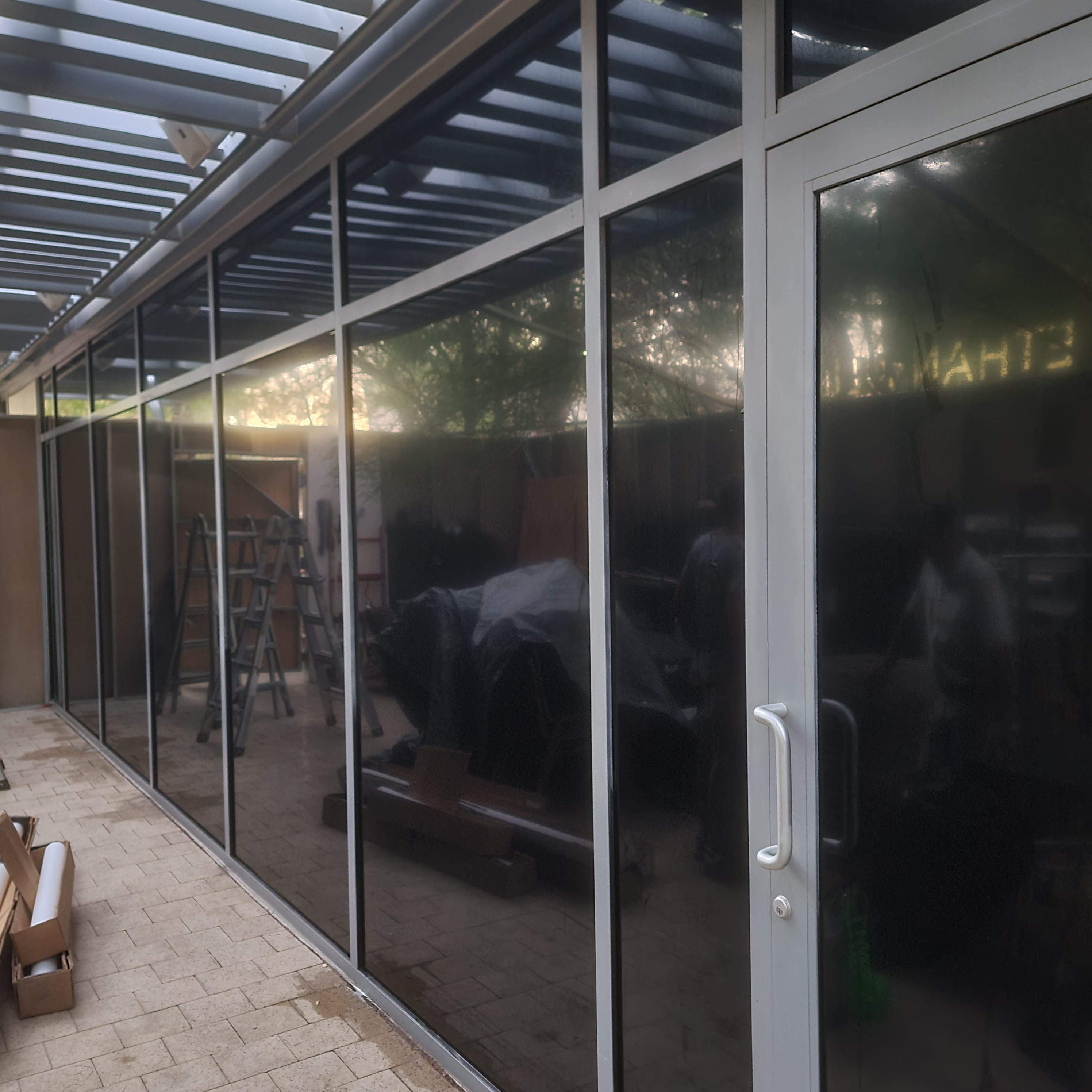 Glass enclosure window film installation progress